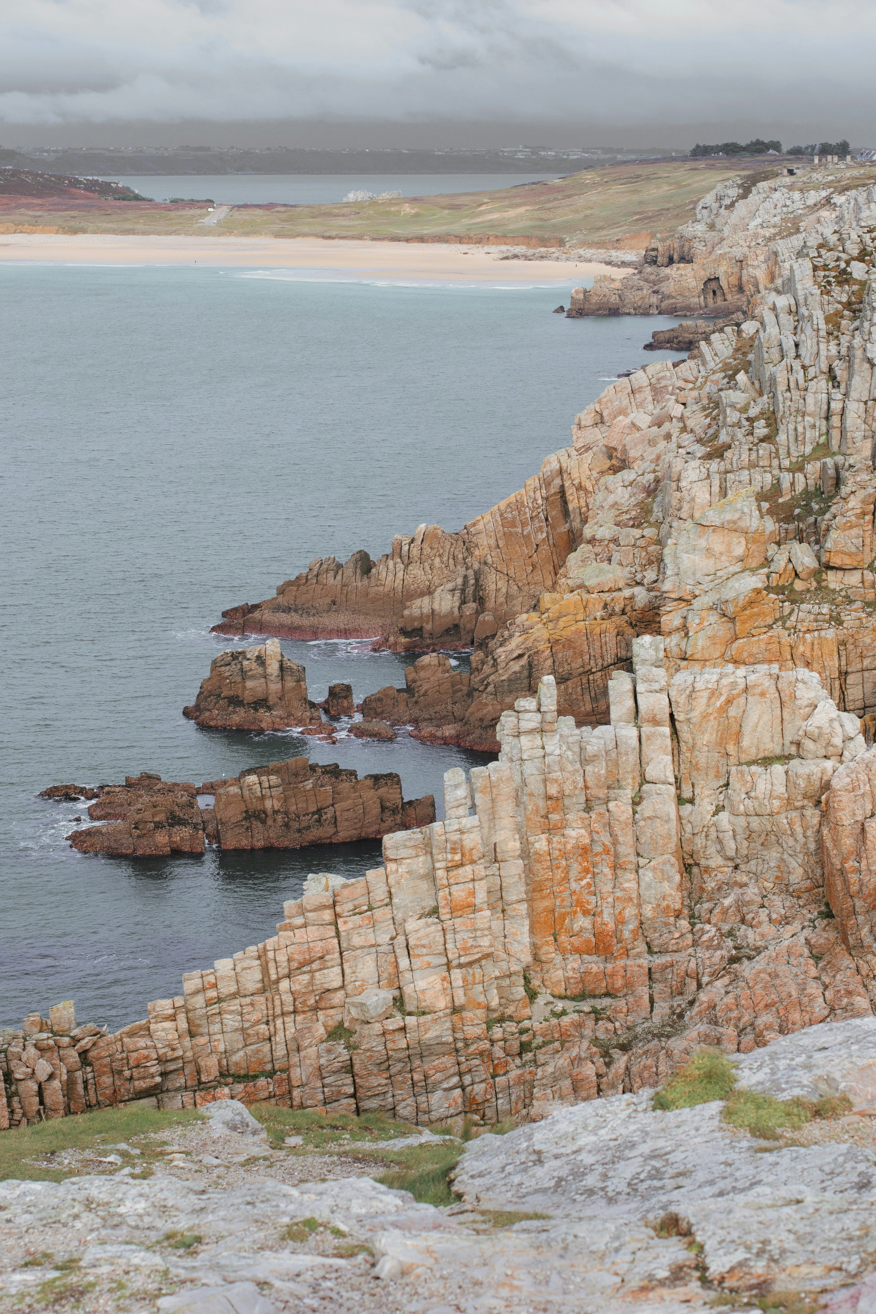 brown rock formation near body of water during daytime